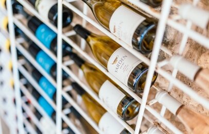 בקבוקי יין תלויים על קיר במסעדת פורט לוקאל ביסרטו